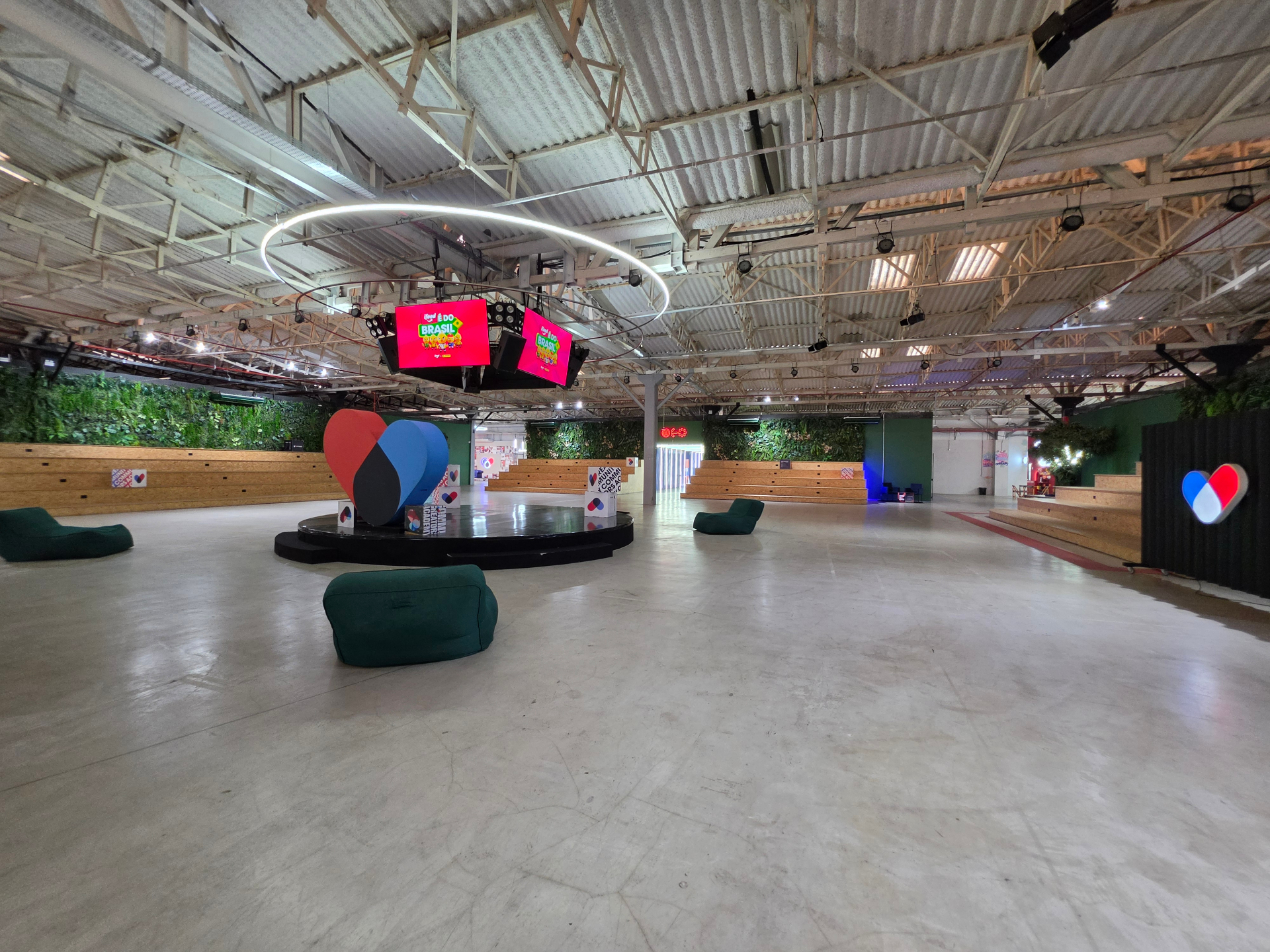 Área ampla de eventos da Community com arquibancadas e palco central.