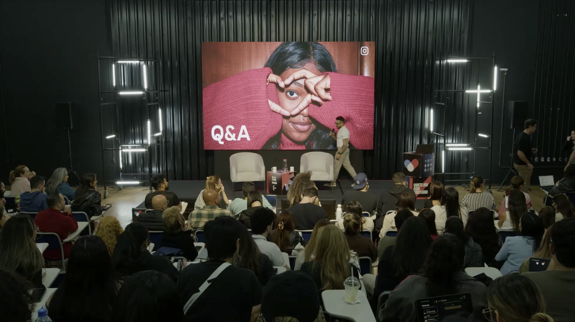 Auditório da Community durante sessão de Q&A com plateia e telão.